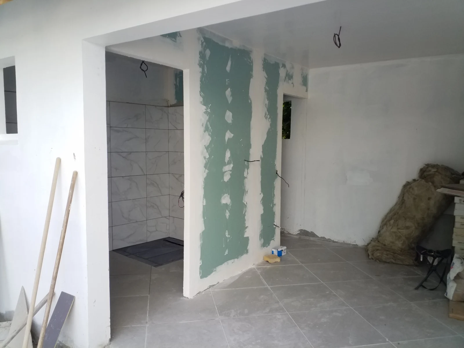 Nouvel agencement intérieur avec sol carrelé et espace douche, finitions en cours
