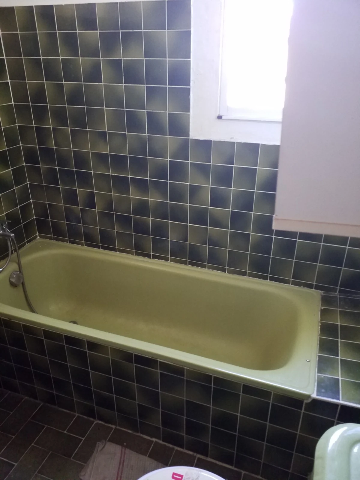 Avant rénovation : baignoire et ancien carrelage de la salle de bains