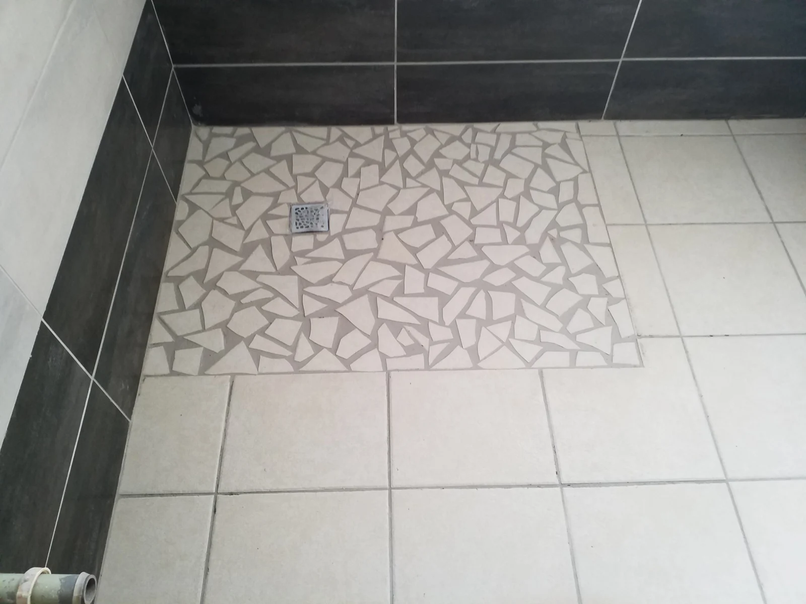 Détail du sol de la douche et de son évacuation